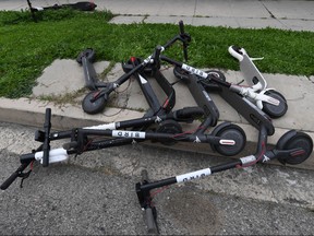 Shared electric scooters lie on a sidewalk in Los Angeles, California on February 13, 2019.