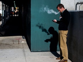 A man smokes an electronic cigarette, also known as an e-cigarette, in New York on November 15, 2017.