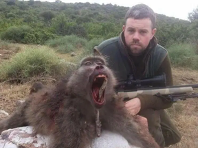 A Brit hunter poses with the baboon he killed in South Africa.