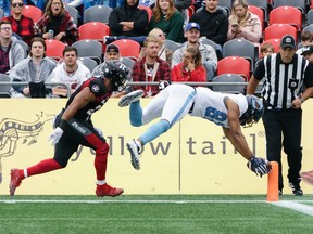Rodney Smith of the Argonauts dives into the end zone for a touchdown yesterday as Redblacks’ Justin Howell gives chase. The Argos won 46-17, their first road victory since 2017. Jana Chytilova/Postmedia