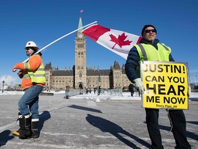 Convoy for Canada protesters march with the Canadian flag and hold a sign for the Canadian Prime Minister on Parliament Hill in Ottawa, Ontario, on February 19, 2019. (LARS HAGBERG/AFP/Getty Images)
