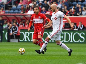Toronto FC midfielder Michael Bradley kicks the ball past Chicago Fire forward Nemanja Nikolic at SeatGeek Stadium Sunday. USA TODAY