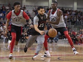Toronto Raptors' Fred VanVleet runs past defenders Patrick McCaw (left) and Chris Boucher during an intra-squad scrimmage at training camp practice in Quebec City on Thursday. (THE CANADIAN PRESS)