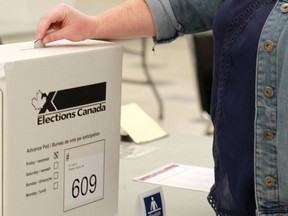 Evangeline Ross drops her ballot in the box while taking part in the advance voting at the Rosscarrock Community Association for the federal election on October 9, 2015.