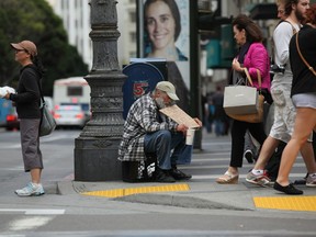 A man holds a sign as he panhandles for spare change in San Francisco. (Justin Sullivan/Getty Images files)