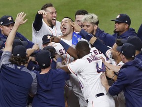 The Houston Astros celebrate with Carlos Correa after his walk-off solo home run in the 11th inning in Game 2 of the American League Championship Series against the New York Yankees at Minute Maid Park on October 13, 2019 in Houston, Texas.  (Photo by Tim Warner/Getty Images)