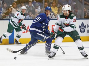 Wild’s Ryan Hartman (right) tries to control the puck in front of Maple Leafs’ Ilya Mikheyev Tuesday night.  Claus Andersen/Getty Images