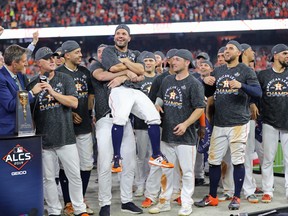 Jose Altuve of the Houston Astros gets lifted off his feet after being named ALCS MVP following his team's 6-4 win over the New York Yankees in Game 6 at Minute Maid Park on October 19, 2019 in Houston, Texas. (Photo by Elsa/Getty Images)