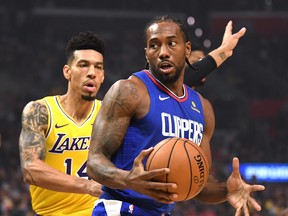 LOS ANGELES, CALIFORNIA - OCTOBER 22:  Kawhi Leonard #2 of the LA Clippers spins for a shot in front of Danny Green #14 of the Los Angeles Lakers during a 112-102 Clipper win in the LA Clippers season home opener at Staples Center on October 22, 2019 in Los Angeles, California. (Photo by Harry How/Getty Images)