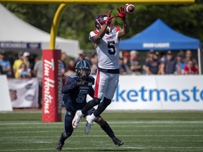 Montreal Alouettes' DeVier Posey makes a catch against Toronto Argonauts' Jermaine Gabriel during their game earlier this season. (THE CANADIAN PRESS)