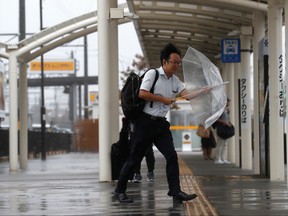 Passenger holds an umbrella in heavy rain and wind after getting off from a train at Shiroko, Suzuka, Japan Oct. 12, 2019, ahead of Typhoon Hagibis. REUTERS/Soe Zeya Tun