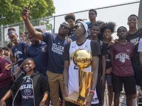 Raptors’ Chris Boucher poses for fans with the Larry O’Brien trophy during a homecoming visit in July.  The Canadian Press