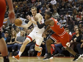 Toronto Raptors guard Matt Thomas drives to the net against Chicago Bulls guard Kris Dunn on Saturday night. (THE CANADIAN PRESS)