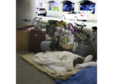 A woman sleeps surrounded by her belongings on Lower Simcoe Street in Toronto on Friday, October 4, 2019. Veronica Henri/Toronto Sun/Postmedia Network