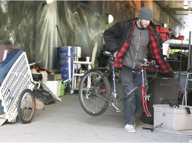 A homeless man decides which items he will toss and what he hopes to keep after city workers ask him to clean up his belongings on Lower Simcoe Street in Toronto on Friday October 4, 2019. Veronica Henri/Toronto Sun/Postmedia Network