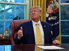 US President Donald Trump gestures as he speaks after announcing and initial deal with China while meeting the special Envoy and Vice Premier of the People's Republic of China Liu He at the Oval Office of the White House in Washington, DC on October 11, 2019.