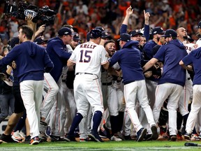 Houston Astros players mob Jose Altuve following his ninth-inning walk-off two-run home run in Game 6 on Saturday night to defeat the New York Yankees in the ALCS. (Elsa/Getty Images)