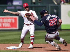 Cardinals second baseman Kolten Wong (left) turns a double play against Braves third baseman Josh Donaldson (right) in the fourth inning in Game 4 of the NLDS at Busch Stadium in St. Louis, on Monday, Oct. 7, 2019.