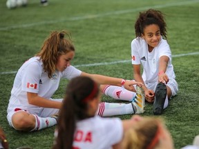 Canadian girls team players (from left) Amalia Cadieux and Felicia Roy do some stretching exercises as they prepare for the Danone Nations Cup in Spain.