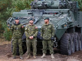 Canadian Army soldiers stand next to their LAV 6 armoured personnel carrier during NATO enhanced Forward Presence battle group military exercise Silver Arrow in Adazi, Latvia, on Oct. 5, 2019.