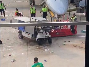 A cart spinning out of control on the tarmac at O'Hare airport in Chicago is stopped by a worker operating a red vehicle. (Screengrab)