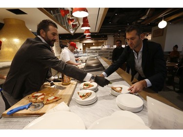 Handing out freshly made Margherita pizza at the preview for the The grand opening of 55,000 square foot Eataly Toronto grocery store - the first in Canada - is set to open in the Manulife Centre on November 13. on Wednesday October 30, 2019. Jack Boland/Toronto Sun/Postmedia Network