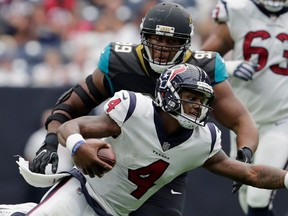 Texans QB Deshaun Watson (4) scrambles while being pursued by Eli Ankou (99) of the Jaguars at NRG Stadium in Houston, on Sept. 10, 2017.