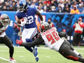 Running back Wayne Gallman of the New York Giants carries the ball against defensive end Jason Pierre-Paul of the Tampa Bay Buccaneers in the second quarter at MetLife Stadium on November 18, 2018 in East Rutherford, New Jersey.