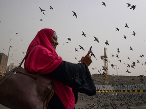 A Muslim pilgrim snaps pictures of pigeons as she walks in the streets of the Saudi holy city of Mecca on August 6, 2019, a few days ahead of the annual Hajj pilgrimage. (FETHI BELAID/AFP/Getty Images)