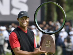 Tiger Woods holds a winning trophy as he celebrates to win the Zozo Championship, a PGA Tour event, at Narashino Country Club in Inzai, Chiba Prefecture, east of Tokyo, Japan October 28, 2019, in this photo released by Kyodo.