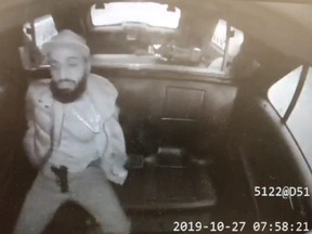 An image taken from video of a suspect in the back of a Toronto Police cruiser with a gun on his lap.