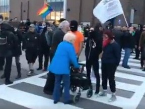 An elderly woman using a walker is prevented from entering a Maxime Bernier event in Hamilton in September. (Screengrab)