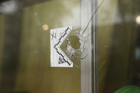 A bullet hole is seen in the kitchen window of a townhouse unit Wednesday, Oct. 9, 2019 a day after a double fatal shooting on Grandravine.