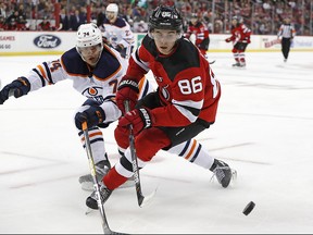 Edmonton Oilers defenceman Ethan Bear (74) defends New Jersey Devils centre Jack Hughes (86) during an NHL hockey game Thursday, Oct. 10, 2019, in Newark, N.J. (AP Photo/Kathy Willens)