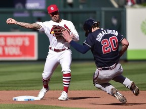 Braves third baseman Josh Donaldson tries in vain to break up a double play as Cardinals second baseman Kolten Wong throws to first during Game 4 of the NLDS at Busch Stadium.  USA TODAY Sports