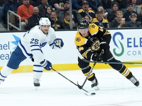 Toronto Maple Leafs defenseman Kevin Gravel, left, pokes the puck away  from Boston Bruins right wing Chris Wagner during the first period at TD Garden in Boston, Oct. 22, 2019. (Bob DeChiara-USA TODAY Sports)