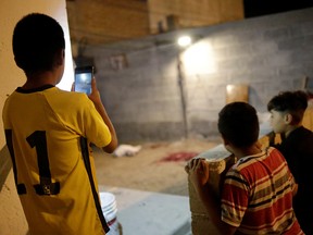Children look on at a crime scene after a journalist from National Geographic was shot in the leg late Friday while interviewing an alleged drug dealer in Ciudad Juarez, Mexico October 4, 2019. (REUTERS/Jose Luis Gonzalez)