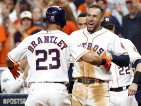 Astros' Michael Brantley is congratulated by teammate George Springer after hitting a solo home run against the Rays during the eighth inning in Game 5 of the American League Division Series at Minute Maid Park in Houston on Thursday, Oct. 10, 2019.