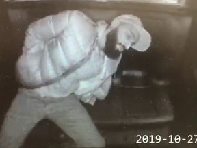 Screencapture of Toronto police in-car surveillance video of a handcuffed Ali Showbeg, 38, removing a handgun concealed in his clothing on Sunday, Oct. 27 2019