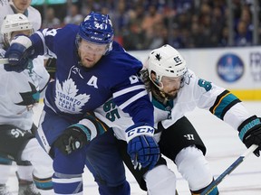 Maple Leafs defenceman Morgan Reilly (44) battles San Jose Sharks counterpart Erik Karlsson at Scotiabank Arena on Friday night. Reilly had what proved to be the winning goal. (Hans Deryk/The Canadian Press)