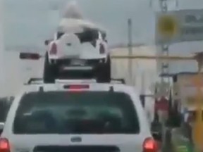 Cops are investigating after an SUV was filmed with two kids in a toy car strapped to the roof.