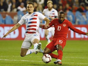 United States defender Aaron Long and Canada forward Junior Hoilett vie for the ball during second half of CONCACAF Nations League soccer action in Toronto, Tuesday, Oct. 15, 2019.