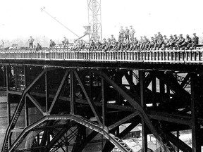 In this tightly cropped version of a photograph in the City Of Toronto Archives collection of Prince Edward Viaduct (aka Bloor Street Viaduct) construction views, we see the first people to perform a "sit-in" on the bridge. The date is March 14, 1917 and the reason for this "sit-in" was simple: The construction company, the Hamilton Bridge Company, simply wanted a commemorative picture.