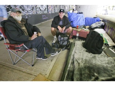 A group of men gather on Lower Simcoe Street in Toronto on Thursday, October 3, 2019. A makeshift bed is home to some. Veronica Henri/Toronto Sun/Postmedia Network