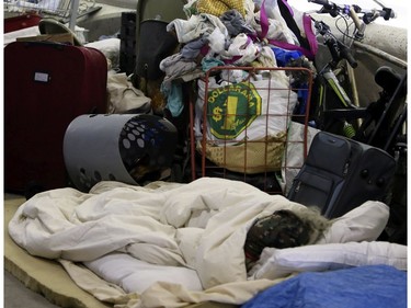 A woman sleeps surrounded by her belongings on Lower Simcoe Street in Toronto on Thursday, Oct 3, 2019. Veronica Henri/Toronto Sun/Postmedia Network