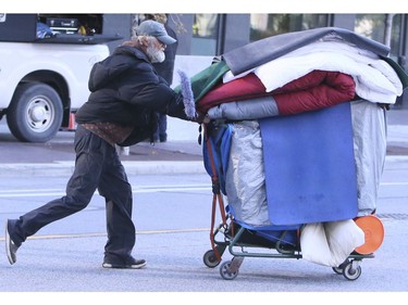 A homeless man clears out his belongings and heads to a local park on Lower Simcoe Street in Toronto on Friday, October 4, 2019. City workers evicted this homeless living there. Once the workers clean the streets of discarded items, he plans to return. Veronica Henri/Toronto Sun/Postmedia Network