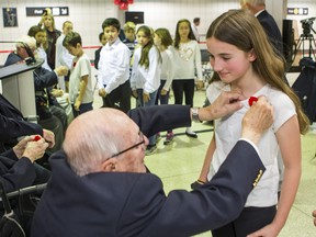 Kierstyn, a grade 6 student from Davisville Junior Public School receives a poppy from Air Force and Army veteran Ken Linn during the official Toronto Royal Canadian Legion annual poppy campaign launch at North York Centre Station in Toronto, Ont.  on Friday October 25, 2019. The Toronto Royal Canadian Legion was joined by TTC war and peacekeeping veterans, veterans from SunnybrookÕs War Veterans Wing and children from Davisville Junior Public School for its annual poppy campaign launch. Ernest Doroszuk/Toronto Sun/Postmedia
