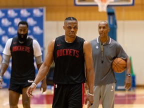 Rockets’ Russell Westbrook (front) and James Harden walk off the court in Tokyo yesterday. The two stars will have to learn to share the ball with each other this season.    Rakuten