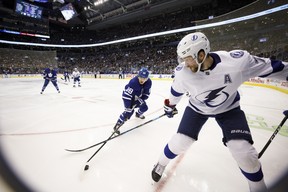 Maple Leafs’ William Nylander (left) and Alex Killorn of the Tampa Bay Lightning dig for the puck in the corner during Thursday night’s game in Toronto. (Cole Burston/The Canadian Press)