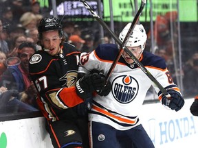 Rickard Rakell of the Anaheim Ducks is checked by Matt Benning of the Edmonton Oilers during the third period of a game at Honda Center on November 10, 2019 in Anaheim, California.